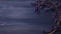 Purple berries wreath on dark blue wooden background with copy space, natural organic decoration for seasonal greeting cards and invitations.