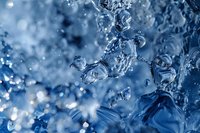 Dynamic water drops and splashes captured in macro photography with blue toning, creating abstract artistic composition perfect for backgrounds and water-themed designs.