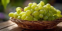 Fresh green grapes in wicker basket on wooden table, natural sunlight highlighting juicy texture for food photography and culinary design.
