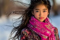 Young Asian woman with flowing dark hair wearing vibrant pink patterned scarf in winter setting, wind blowing through hair against snowy blurred background.