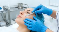Professional cosmetic injection procedure in modern medical clinic with dermatologist administering facial treatment to young woman patient.