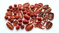 Assorted dried red dates jujube fruits whole and sliced showing interior texture isolated on white background for healthy snacking and cooking ingredients.
