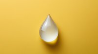 Transparent water drop on bright yellow background, creating minimalist composition with shadow effect for environmental or wellness concepts.