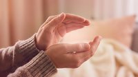 Gentle cupped hands in protective gesture creating warm caring atmosphere for wellness meditation and spiritual healing concepts.