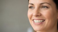Happy smiling woman with dental braces showing teeth, orthodontic treatment concept for healthcare and dental care advertising materials.