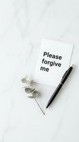 Please forgive me note card with black pen and eucalyptus branch on white marble surface, apology and reconciliation concept.