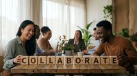 Diverse team building wooden letter blocks spelling COLLABORATE in bright modern office space with plants and natural light streaming through windows.