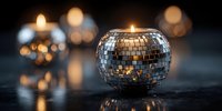 Glowing disco ball candle holder with warm light reflecting off mirrored mosaic surface against dark background with bokeh lights.