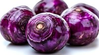 Fresh purple kohlrabi bulbs with glossy skin and natural texture shown in close-up on white background, highlighting vibrant color and organic produce quality.