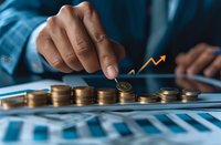 Business professional analyzing financial growth with stacked coins and upward trending arrow, perfect for investment, banking and wealth management concepts.