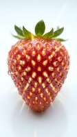 Fresh ripe strawberry with green leafy crown isolated on white background. Bright red fruit with detailed drupelets and natural shine, suitable for food, nutrition, healthy eating, and culinary design projects.