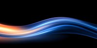 Glowing orange and blue light waves flow smoothly across dark background creating dynamic motion effect for modern technology and energy designs.