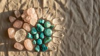 Healing crystals and gemstones arranged in mandala pattern on natural linen fabric with soft shadows for meditation and spiritual wellness practices.