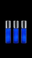 Three cobalt blue glass roller bottles with silver caps, isolated on transparent background. Ready for beauty, skincare, and essential oil product design use.