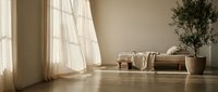 Minimalist interior space with natural light streaming through sheer curtains, wooden bench, potted plant, and folded textiles on polished floor for home decor design.