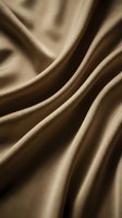 Luxurious beige satin fabric with flowing folds and soft draping, showcasing smooth texture and elegant waves. Suitable for fashion, textile, and interior design projects.