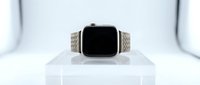 Modern smartwatch with woven fabric sport band displayed on white pedestal against clean studio background for technology and wearable device concepts.