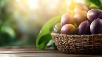 Fresh ripe plums in rustic woven basket on wooden table against blurred garden background with natural sunlight and green leaves. Organic harvest concept.