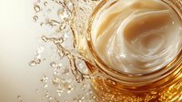 Golden liquid splash with dynamic swirls and droplets creating elegant fluid motion against cream background for luxury beverage advertising.