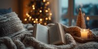Cozy winter evening with open book on knitted blanket, glowing Christmas tree in background and decorative candle creating warm atmosphere.