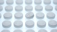 White pharmaceutical tablets arranged in rows with one broken pill showing medical medication concept for healthcare and treatment applications.
