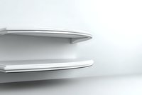Minimalist white floating shelves against light background create modern architectural detail with clean lines and subtle shadows for interior design concepts.