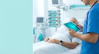 Male healthcare professional using digital tablet in modern hospital room with patient and medical equipment for telemedicine consultation.