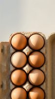 Fresh brown eggs arranged in cardboard carton for organic farming and healthy breakfast cooking ingredients.