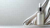 Frosted glass cosmetic dropper bottle on luxurious white silk fabric with soft folds creating elegant composition for beauty product presentation on light background.