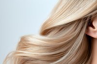 Flowing blonde hair strands in motion against light background, showcasing smooth, healthy texture and natural highlights for beauty and haircare advertising.