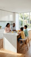 African American family of four enjoying breakfast together at a marble kitchen island with fresh juice and food, bright modern kitchen with white cabinetry and garden views.