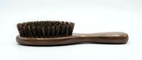 Wooden hairbrush with natural bristles and rustic handle, suitable for hair care, grooming, wellness, and beauty product photography.