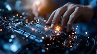 African American hands typing on illuminated keyboard with glowing orange light effects and bokeh, creating atmospheric cybersecurity and technology concept in dark blue tones.