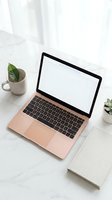 Rose gold laptop with blank white screen on marble desk workspace with coffee mug, plants and notebook for remote work and productivity mockup design.