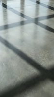 Abstract geometric shadows cast on concrete floor creating dramatic light and dark patterns for modern architectural design backgrounds.