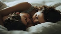 Intimate couple embracing in bed sharing tender moment together in soft morning light creating romantic atmosphere for relationship and love concepts.