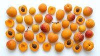 Apricots whole and halved with pits displayed on white background, suitable for food photography, culinary content, nutrition guides, recipe blogs, and healthy eating promotions.