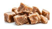 Sweet caramel candy pieces with nuts isolated on white background for confectionery designs and dessert projects.