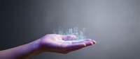 Glowing holographic cityscape floating above open palm, representing smart city technology, digital innovation, and future urban development solutions.
