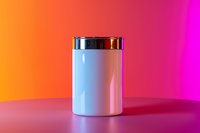 White cylindrical container with metallic lid on vibrant gradient background from orange to pink, modern minimalist product photography for cosmetics or supplements packaging.