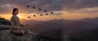 Asian woman meditating in lotus pose on mountain cliff at dramatic sunset, birds flying in formation, peaceful mindfulness concept.