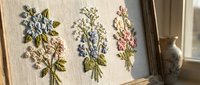 Delicate hand embroidered floral bouquets on natural linen fabric featuring blue and pink wildflowers with green leaves in traditional needlework style.