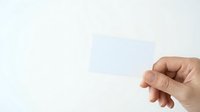 Hand holding blank translucent business card against white background, suitable for branding, corporate identity, and marketing mockup presentations.