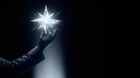 Gloved hand holding bright star light against dark background, symbolizing hope, innovation, and success for business and inspirational concepts.
