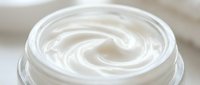 Creamy white swirled texture in glass jar, smooth cosmetic cream or moisturizer with luxurious spiral pattern for skincare and beauty product packaging.