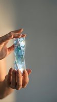 Hands holding transparent holographic display showing futuristic skyscraper architecture with digital interface elements for technology and innovation concepts.