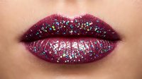 Closeup of full lips with deep burgundy glitter makeup, sparkly cosmetic application for beauty and fashion design projects.