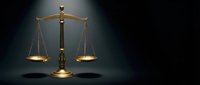 Golden brass scales of justice on dark background symbolizing law, legal system, court proceedings, and judicial balance in professional legal services.