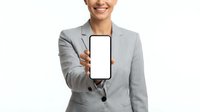 Smiling businesswoman in gray blazer holding smartphone with blank white screen for app mockup or advertisement display.