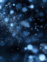Glowing blue particles and bokeh lights scattered on dark background create magical atmosphere for festive designs and winter holiday backgrounds.
